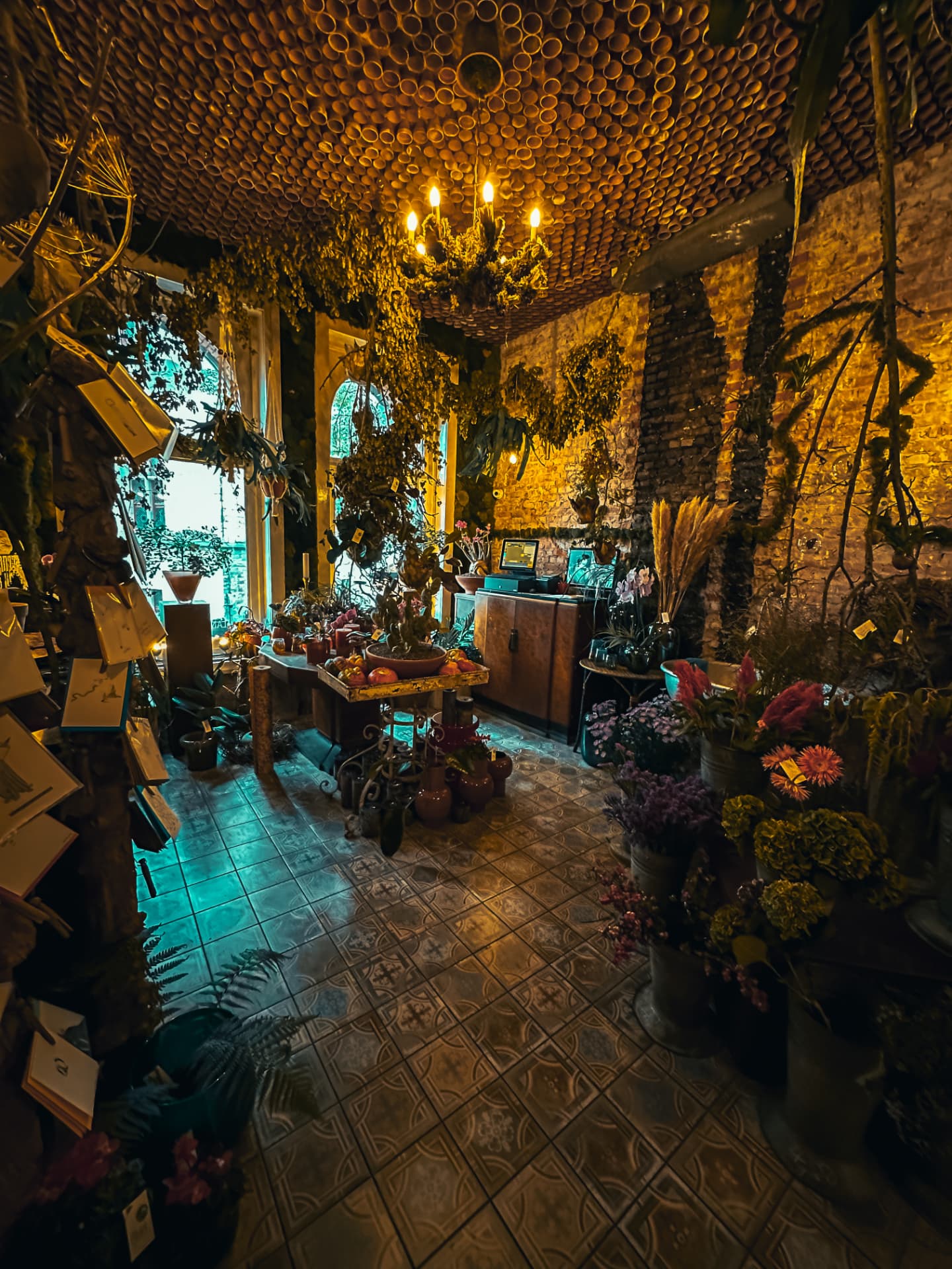 Warmly lit flower shop interior with terracotta ceiling and fresh bouquets