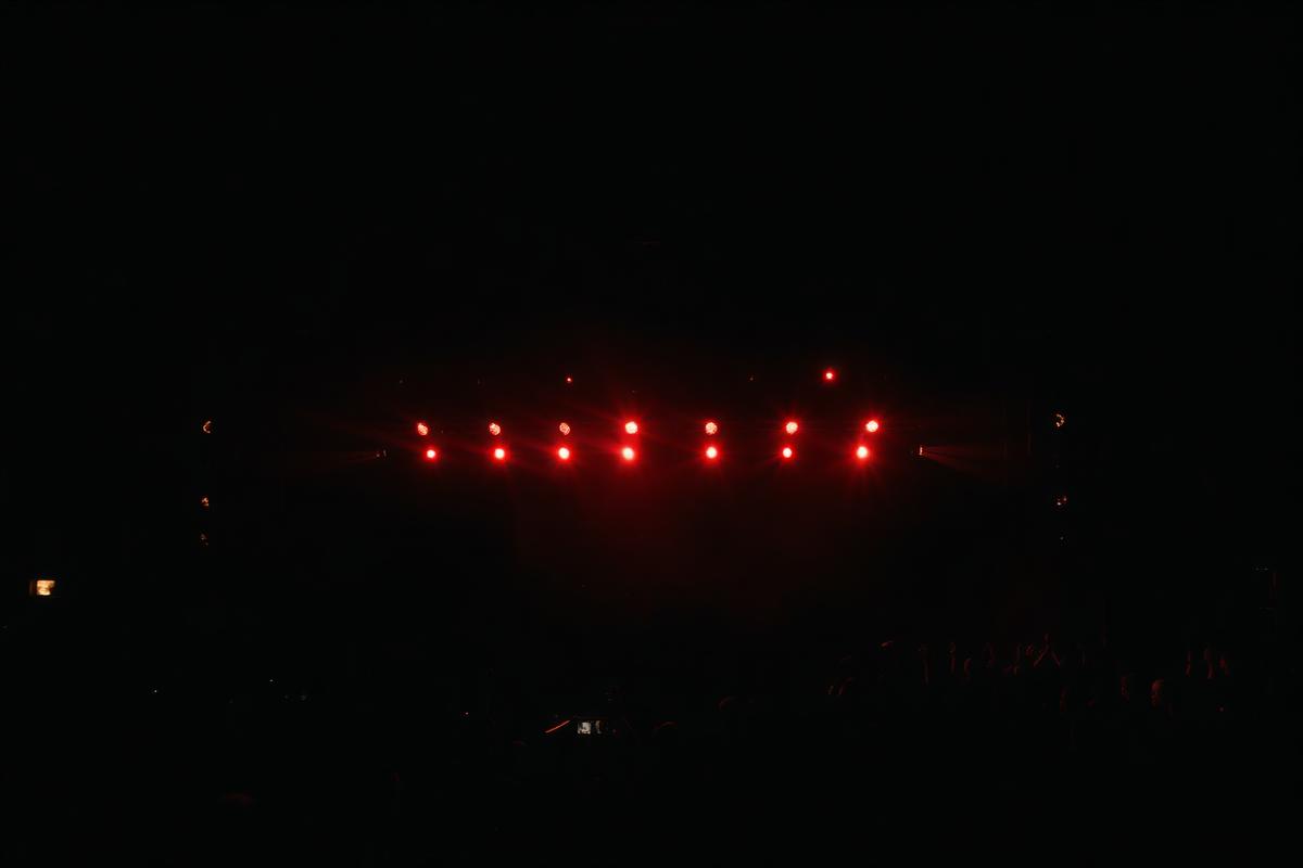 Concert stage lights above a festival crowd